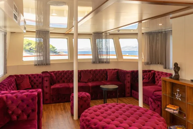 Red couches and table on yolo yacht